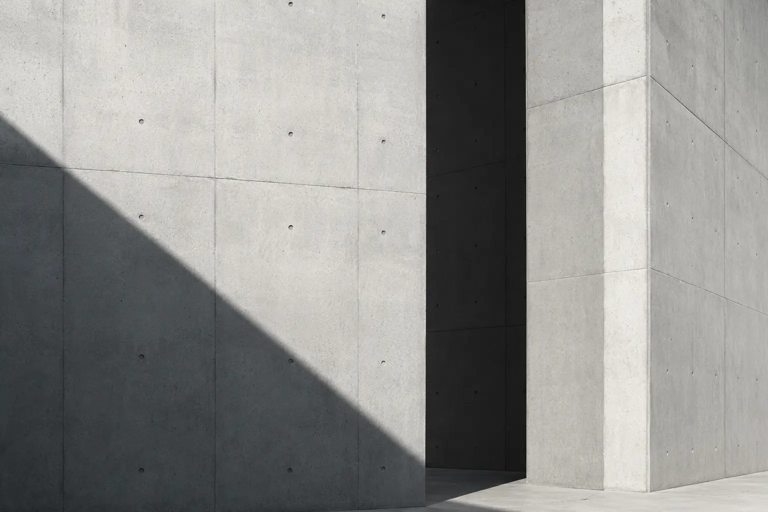 Minimal concrete architecture shaped by sharp light and shadow